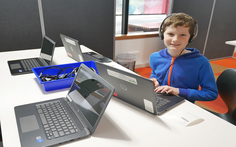 Photo of young boy using Library laptops