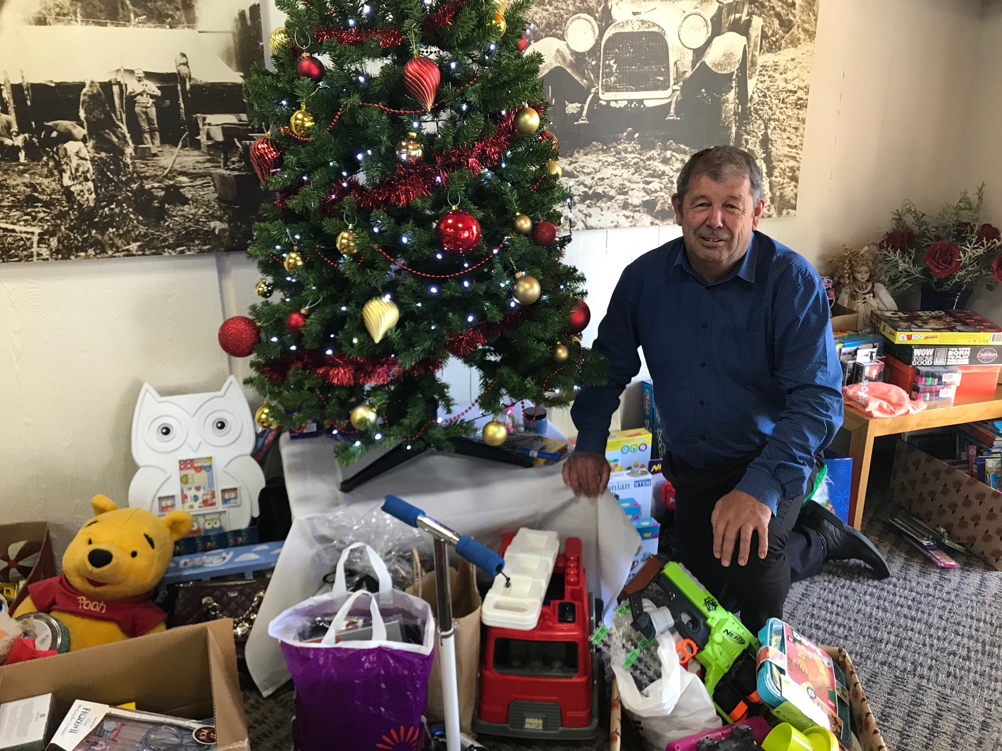 Neil Volzke with donated goodies under the Christmas Tree from previous years
